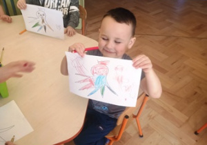 chłopiec pokazuje rysunek